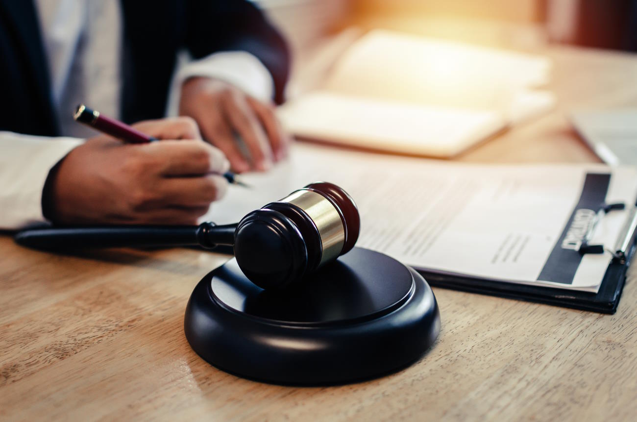 justice lawyer in black suit working about legal legislation with documents on workplace and wooden judge gavel on desk in courtroom office, business adviser, justice law and legal service concept